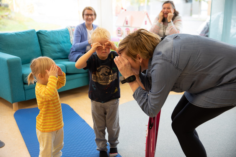 Lapset ja aikuiset tihrustavat.