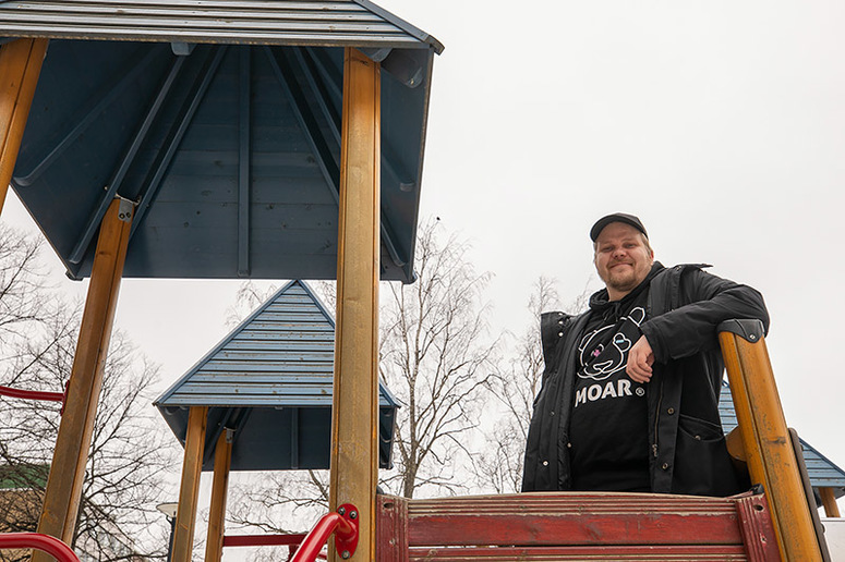 Lippalakkipäinen mies leikkikentän liukumäkirakenteissa.