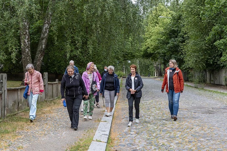 Joukko naisia kävelee ulkona.