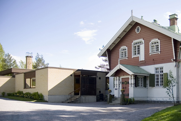 Vanha koristeellinen ja uudempi pelkistetty rakennus vierekkäin ulkona.