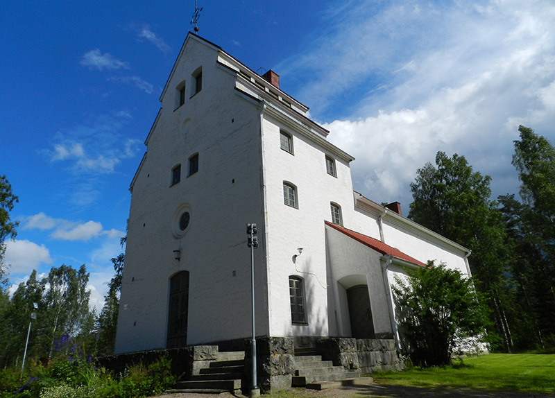 Jyhkeästi kohoava kivinen rakennus kuvattuna alhaalta päin.