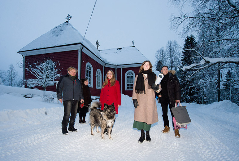 Ihmisiä ja koira pakkasessa, taustalla kirkkoa.