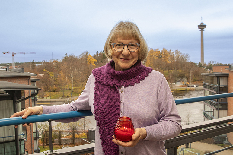 Marjut Kuokkanen pitää kynttilälyhtyä kädessään.