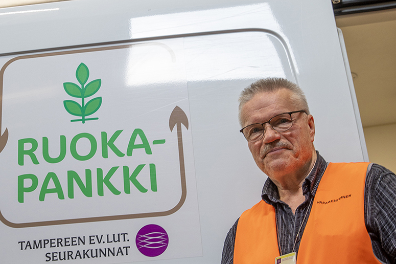 Esa Matikainen kantaa ruokalaatikkoa autoon.