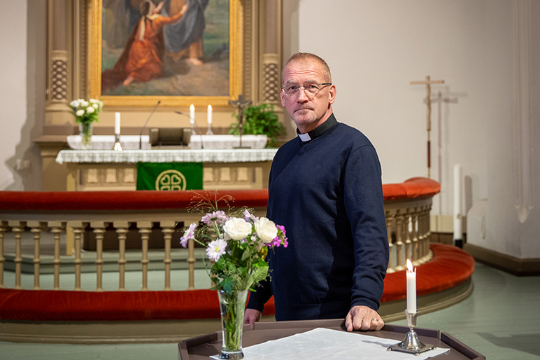 Jari Kuusi seisoo Messukylän kirkon kuorissa, taustalla näkyy alttari ja alttarimaalaus.