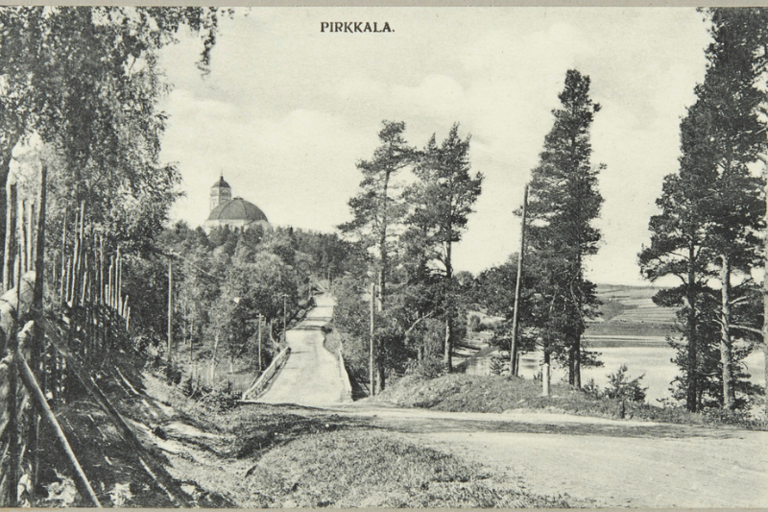 Vanha kuva, jossa näkyy tietä, metsää ja horisontissa kirkko.